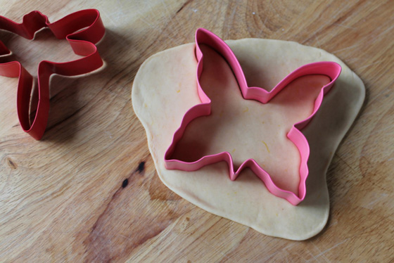 butterfly cookie cutter being used to cut out pumpkin fritter dough