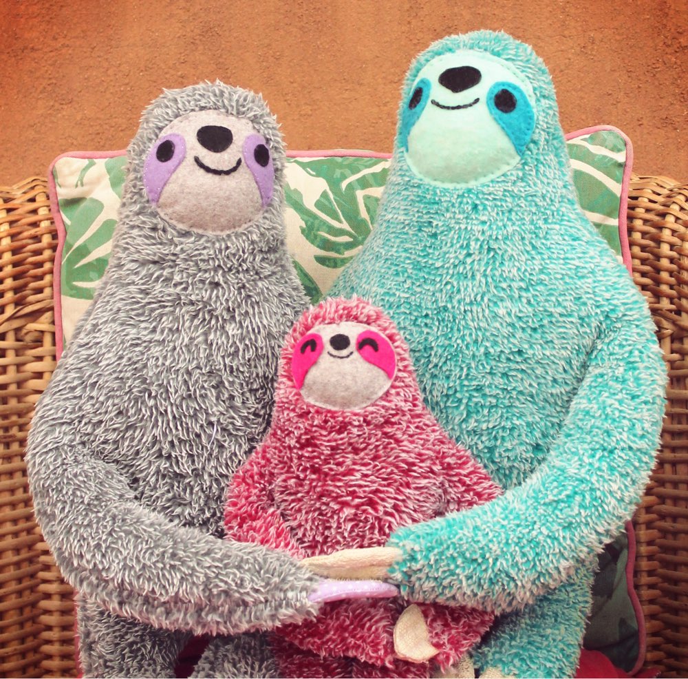 A family of DIY sloth plushies sit for their family portrait